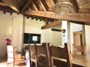 a dining room with a table and chairs and a chandelier at Cases de Canillo-Casa Sant Joan de Caselles in Canillo