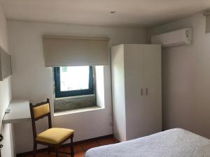 1 dormitorio con 1 cama, 1 silla y 1 ventana en Angelas - Casa da Galega, en Vila Praia de Âncora