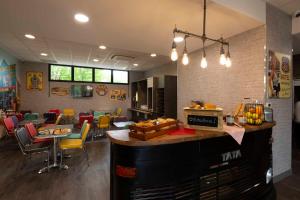 a restaurant with a bar with chairs and tables at Break H&ocirc;tel in Vierzon