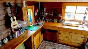 Mas'ada的住宿－Cantina Cabin's - Think Nature，厨房配有木台,墙上挂有吉他
