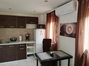 a small kitchen with a table and a refrigerator at Rezeda Apartman in Gárdony