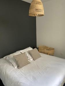 a white bed with two pillows in a bedroom at Le beffroi in Calais