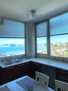 a kitchen with windows with a view of the ocean at ANISA Vlore in Vlorë