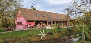 a large pink building with a house at La Maison Du L.A.C. in Simard