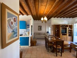 a kitchen and dining room with blue cabinets and a table at Pigeon House Ornos Beach in Mikonos