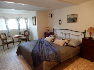 Vila Nízke Tatry في Horná Lehota: غرفة نوم بسرير وطاولة وكراسي
