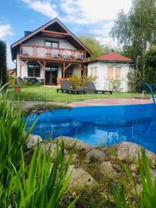 a house with a pool in front of it at Chata Zaciszne Zastań in Międzywodzie
