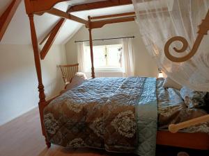 ein Schlafzimmer mit einem Himmelbett und einem Fenster in der Unterkunft Bij de Friesche Poort in Bourtange