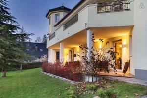 a large white house with a lawn in front of it at Alpine apartments Marcella in Žirovnica