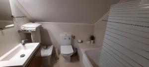 a bathroom with a toilet and a sink and a tub at CasAzulApartments in Sintra