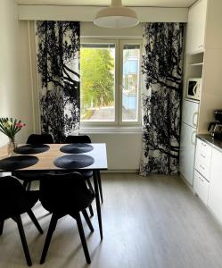Citykoti Kuutti في سافونلينّا: غرفة طعام مع طاولة وكراسي ونافذة