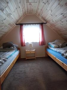 two beds in a room with a window at AGROTURYSTYKA POD ŚNIEŻNĄ in Bystrzyca Kłodzka