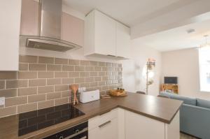 a kitchen with white cabinets and a counter top at McCaig's Way in Oban