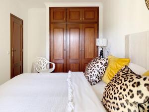 een slaapkamer met een wit bed met kussens erop bij Stylish 3 Bedroom Apartment close to the Beach in Monte Gordo