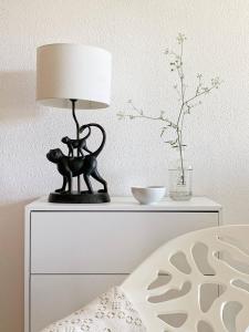 een zwarte kattenlamp op een wit dressoir bij Stylish 3 Bedroom Apartment close to the Beach in Monte Gordo