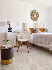 een slaapkamer met een bed, een tafel en een stoel bij Stylish 3 Bedroom Apartment close to the Beach in Monte Gordo