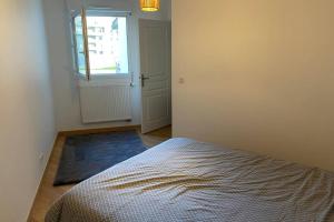 a bedroom with a bed and a window and a door at Jeremy T2 idéalement situéThonon centre avec terrasse et garage in Thonon-les-Bains