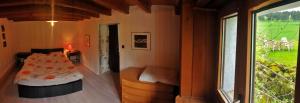 1 dormitorio con 1 cama en una habitación con ventana en Le Petit Brouillet du bas en La Brévine