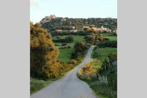 a road in a field with a town in the distance at La Cuppulata - Stile Classico in Enas