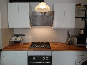 uma cozinha com armários brancos e um forno com placa de fogão em Warsaw Center's Apartment em Varsóvia