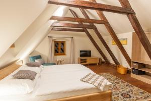 a bedroom with a white bed and a tv at Babyka Apartments in Český Krumlov