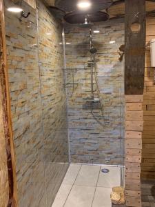a shower in a room with a stone wall at The Bothy Aberlour in Aberlour