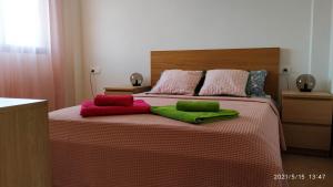 Una cama con 4 almohadas de colores. en Adosado a 300m de la playa, en Bellreguart