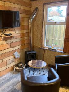 una sala de estar con una pared revestida de madera y una estufa. en The Bothy Aberlour en Aberlour