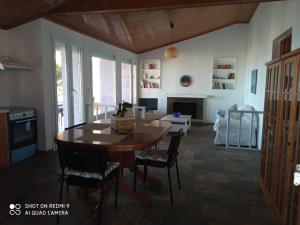 uma cozinha com mesa e cadeiras e uma sala de estar em Villa Evdokia em Katakolo