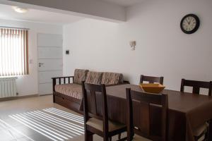ein Esszimmer mit einem Tisch und einem Sofa in der Unterkunft Apartamentos del Sol in San Carlos de Bariloche