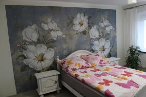 CzystaにあるAgroturystyka Pod Kogutkiemの花柄の壁紙を用いたベッドルーム(ベッド付)