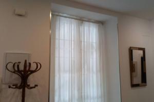 uma janela com uma cortina branca num quarto em Apto Patio Andaluz. Máximo Confort y Limpieza em Cádiz