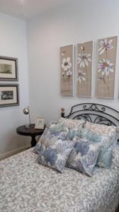 um quarto com uma cama com almofadas em Apto Patio Andaluz. Máximo Confort y Limpieza em Cádiz