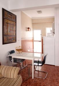 uma cozinha com uma mesa branca e um sofá em Casa José em Rota