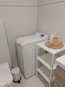 a small white laundry room with a washer and dryer at Hello apartman in Eger