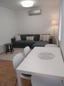 a living room with a couch and a table and chairs at Hello apartman in Eger