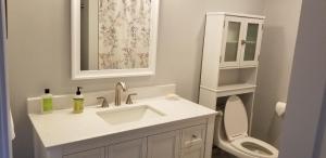a white bathroom with a sink and a toilet at Lakehouse has Spectacular View plus Easy Access! in Rogers +86 photos