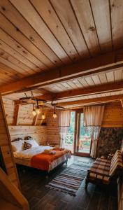 ÇamlıhemşinにあるPurkinora (Çiçek Mevsimi) Bungalovのログキャビン内のベッド1台が備わる広い客室です。