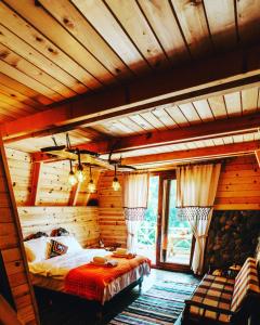 ein Schlafzimmer mit einem großen Bett in einem Blockhaus in der Unterkunft Purkinora (Çiçek Mevsimi) Bungalov in Çamlıhemşin