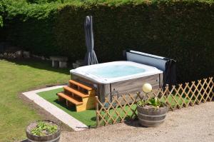 a hot tub in a yard next to a fence at Hôtel Restaurant du Cheval Blanc in Saint-Boil