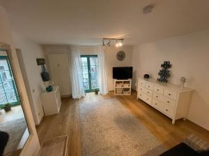 a living room with a television and a white dresser at Fewo am kleinen Hafen in Überlingen