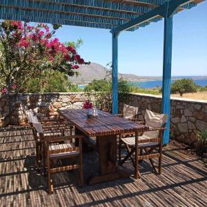Une table et des chaises en bois sont disponibles sur la terrasse. dans l'établissement Kasi's nature home, à Cythère