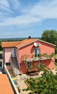 Casa rosa con balcone e tavolo di Apartment Gordana a Pola (Pula)