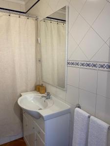 a white bathroom with a sink and a mirror at Casa da Várzea in Odeceixe