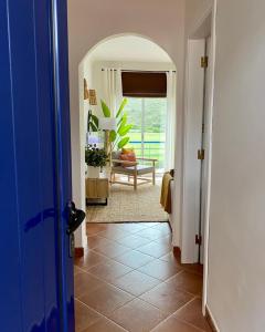 a hallway with a blue door and a living room at Casa da Várzea in Odeceixe