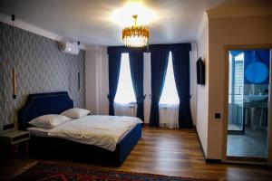 a bedroom with a bed and a chandelier at Hotel Metropol in Derbent