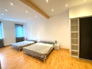 2 Betten in einem großen Zimmer mit Holzböden in der Unterkunft Be my Guest in Mannheim in Mannheim