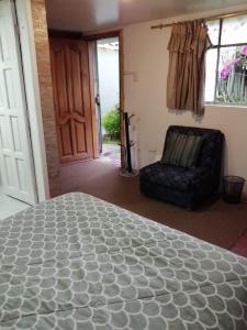 a room with a bed and a chair and a door at Mini suites en el mejor sector de la ciudad in Quito