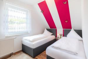 two beds in a small room with red and white stripes at Gästehaus Schulz in Ahlbeck