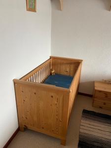 a wooden crib in the corner of a room at Ferienhaus D52 Europa Feriendorf 2-6 Personen in Lichtenau